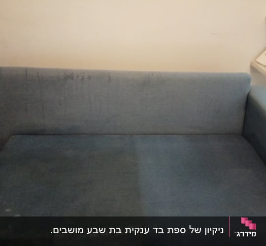 ספה כחולה עם כתמים על המושב והמשענת